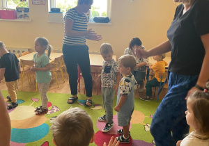 Dzieci wraz z nauczycielką tańczą w kole