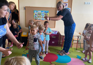 Dzieci wraz z nauczycielką tańczą do piosenki "Krasnoludek"