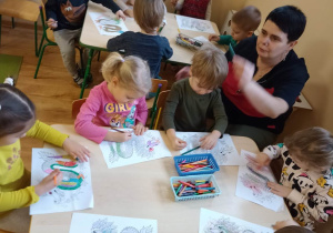 Dzieci wypełniają kredkami kontury chińskiego smoka