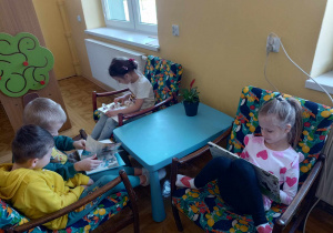 Dzieci oglądają książki na wygodnych fotelach