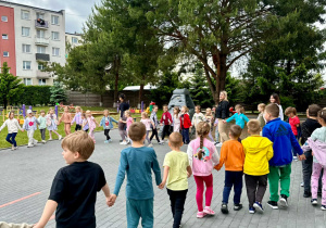 Dzieci tańczą w kole w rytm muzyki