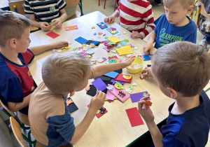 Chłopcy wykonują magnesy dla mamy i taty z wykorzystaniem różnorodnych naklejek