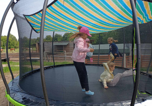 Dzieci skaczą na trampolinie