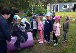 Dzieci utrzymują równowagę w siodle na specjalnych beczkach