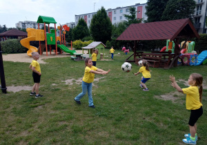 Dzieci rzucają do siebie piłką w parach
