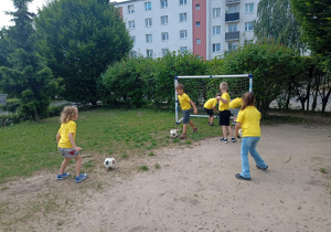 Dzieci celują piłką do bramki