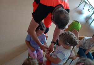 Ratownik medyczny bandażuje rękę dziewczynce