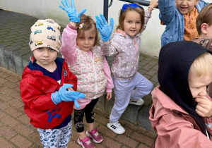 Dzieci pozują do zdjęcia z rękawiczkami do sprzątania świata