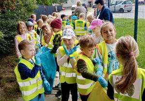 Biedronki i Pszczółki sprzątają śmieci wokół chodnika