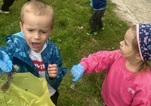 Chłopiec wrzuca plastikowe śmieci do żółtego worka