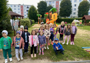 Grupa słoneczka pozuje do zdjęcia na tle placu zabaw