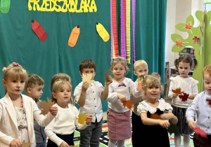 Dzieci tańczą z jesiennymi listkami