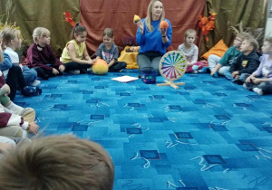 Pani Ania prezentuje dzieciom jesienne dary przyrody