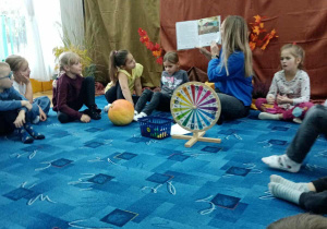 Pani Ania czyta dzieciom książeczkę o tematyce jesiennej