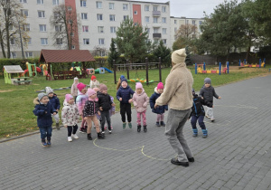 Nauczycielka wskazuje cyfrę, dzieci wykonują zadanie.