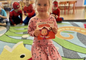 Dziewczynka z książeczką "Masza i Niedźwiedź"