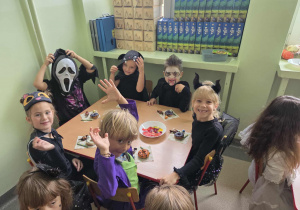 Dzieci częstują się halloweenowymi przekąskami