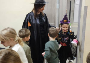 Dzieci biorą udział w wróżbie z butami doprowadzając kolejno byty w kierunku drzwi