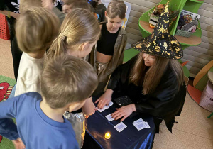 Dzieci ustawiają się w kolejce do Wróżki Marty, która przepowiada przyszłość z kart