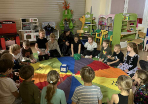 Dzieci w kole kolejno rzucają dwiema kostkami poznając przestrogę