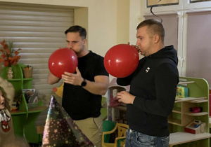 Chętni tatusiowie biorą udział w wróżbie dmuchając balony