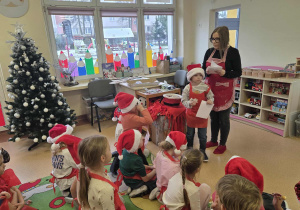 Pani Marzenka wręcza kolejno dzieciom dyplom za udział w warsztatach cukierniczych