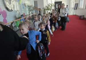 Dzieci wchodzą do sali, w której oglądać będą przedstawienie "O dwóch takich co ukradli księżyc"