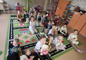 Dzieci odpoczywają na dywanie ze swoimi misiami