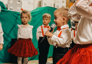 Chłopiec recytuje wiersz do mikrofonu.