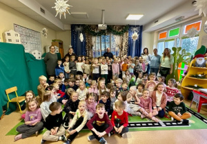 Dzieci wraz z nauczycielkami pozują do zdjęcia wraz z panem policjantem