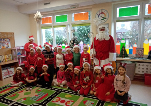 Dzieci wraz z panią i Mikołajem pozują do zdjęcia