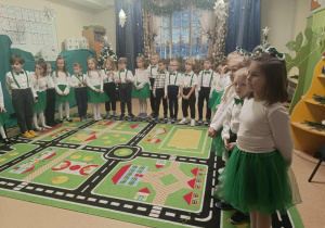 Dzieci ustawione w półkolu czekają na przyjście Mikołaja
