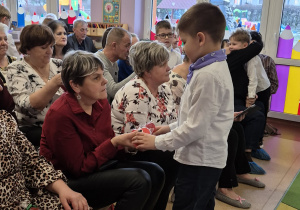 Dzieci wręczają prezenty swoim dziadkom