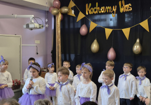 Dzieci kolejno do mikrofonu deklamują wiersze dla swoich dziadków