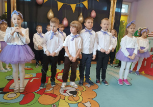 Dzieci kolejno do mikrofonu deklamują wiersze dla swoich dziadków