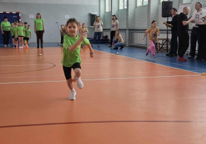 Dziewczynka biegnie do pachołka