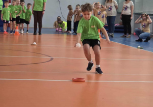 Chłopiec umieszcza piłki w plastikowym ringo - konkurencja na czas