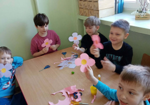 Chłopcy wycinają kwiatki dla dziewczynek z okazji ich święta