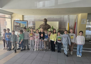 Dzieci pozują do zdjęcia z posągiem patrona szkoły - z Janem Pawłem II