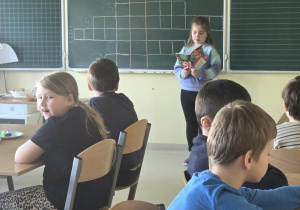 Uczennica klasy I czyta dzieciom fragment lektury szkolnej pt. "Plastusiowy Pamiętnik"