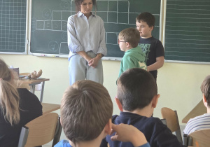 Chłopiec losuje z woreczka jeden z przyborów szkolnych, który musi rozpoznać po dotyku