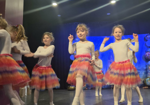 Dziewczynki swobodnie tańczą na scenie do muzyki rozrywkowej