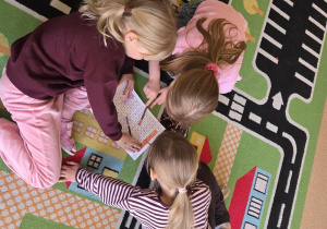 Dzieci w grupach w wykreślance literowej odnajdują nazwy wiosennych kwiatów