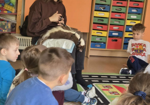 Pani opowiada dzieciom o zwyczajach, sposobie żywienia i pielęgnacji skunksów