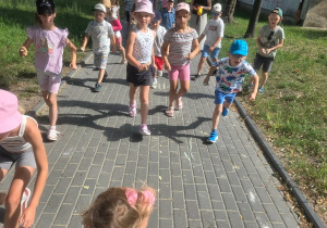 Pszczółki rysują kredą strzałki - kierunek trasy dla przeciwnej grupy