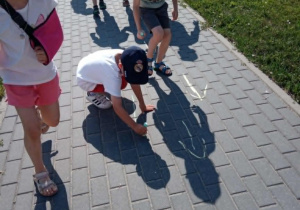 Pszczółki rysują kredą strzałki - kierunek trasy dla przeciwnej grupy