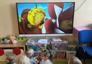 Dzieci oglądają bajkę "Pszczółka Maja" na tablicy multimedialnej