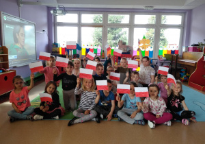 Dzieci pozują do zdjęcia ze zrobionymi przez siebie flagami