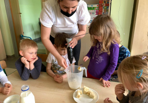 dzieci obserwują jak z bananów, mleka i jogurtu powstaje koktajl