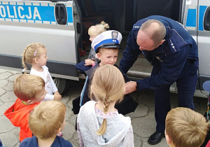 Dzieci przymierzają czapkę policjanta